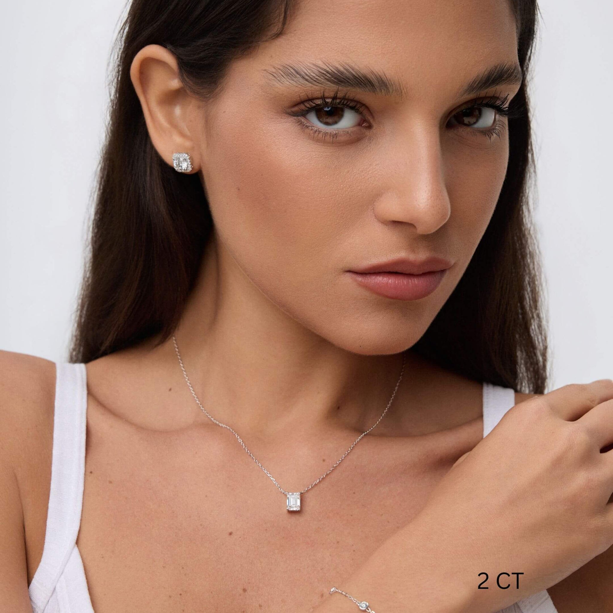 Emerald-cut moissanite pendant necklace worn at the neckline.