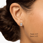 Emerald-cut moissanite stud earrings worn on the ear, 2 ct per pair with 1 ct per stone.