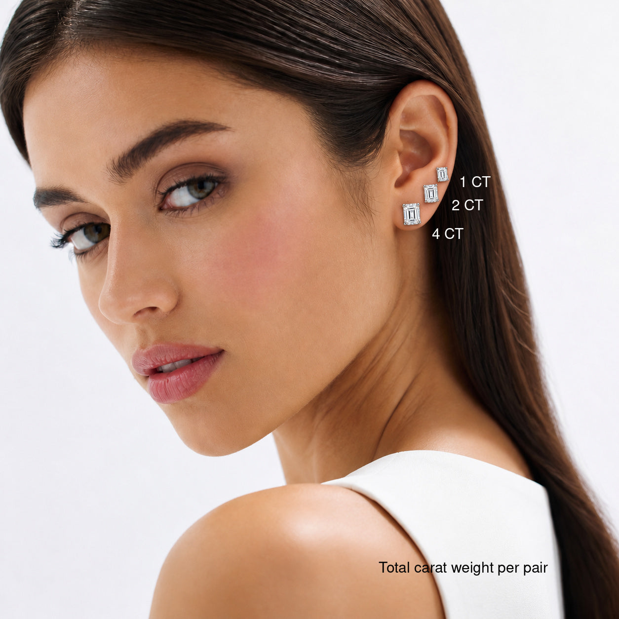 Emerald-cut moissanite stud earrings worn on a model, comparing 1, 2 and 4 ct total carat weight per pair.