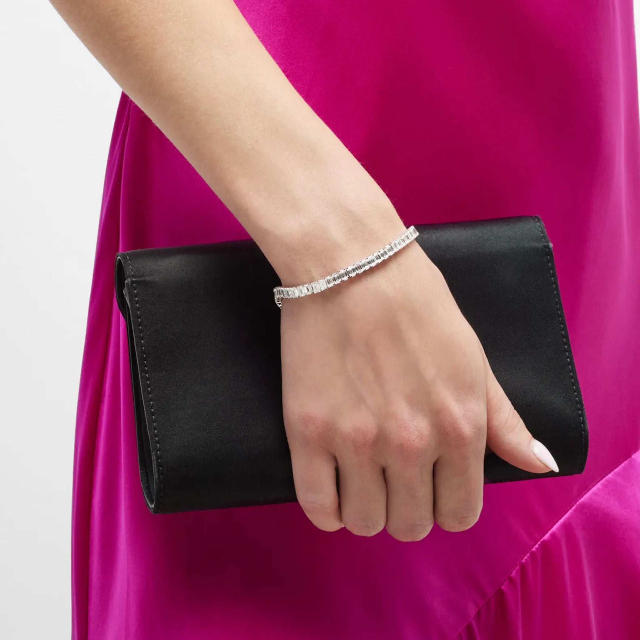 Emerald-cut moissanite tennis bracelet worn on the wrist.