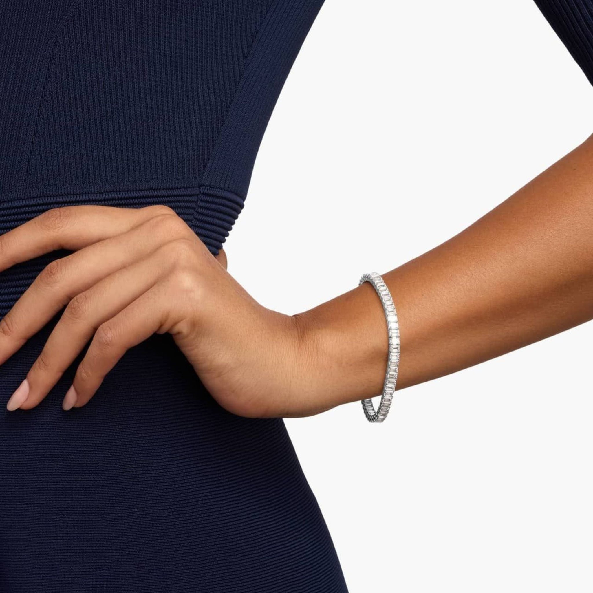 Emerald-cut moissanite tennis bracelet worn on the wrist.