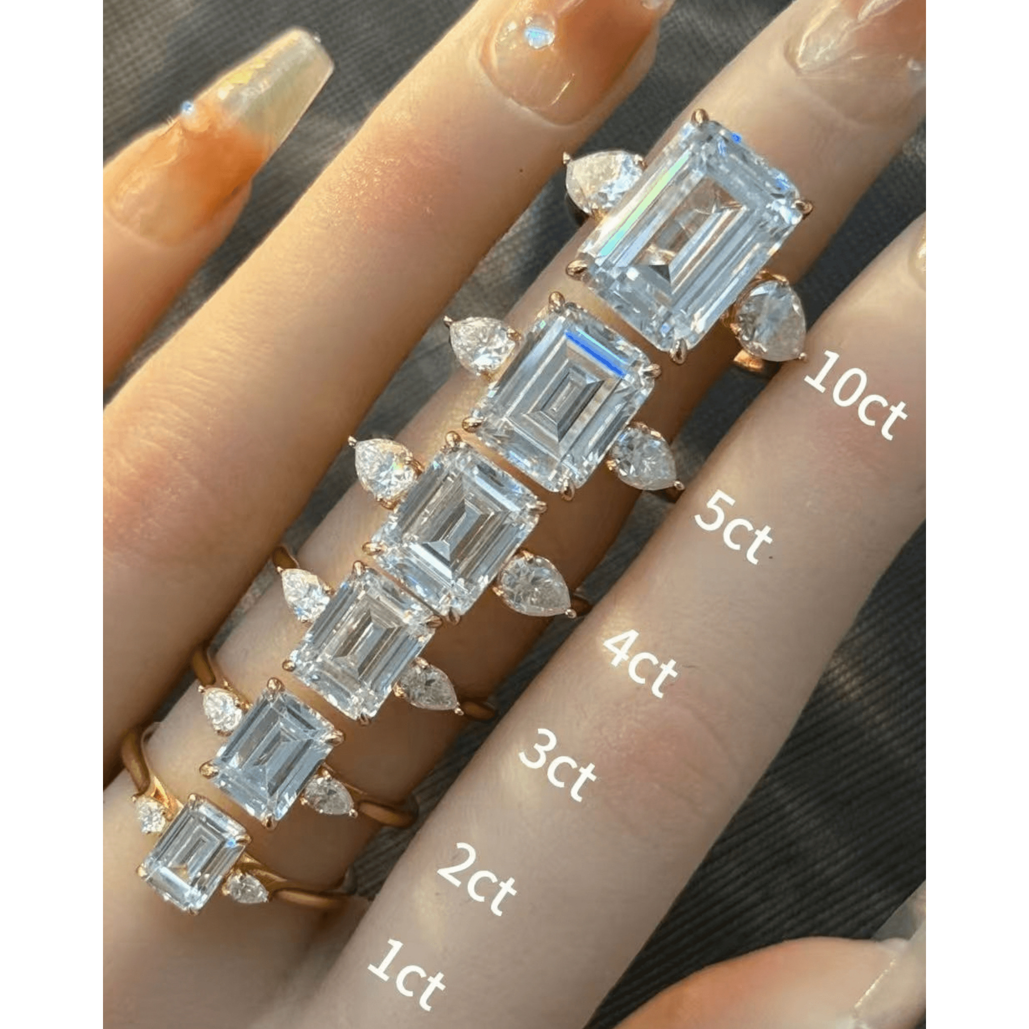 Emerald-cut moissanite three-stone ring rings arranged across fingers for a carat-size comparison.