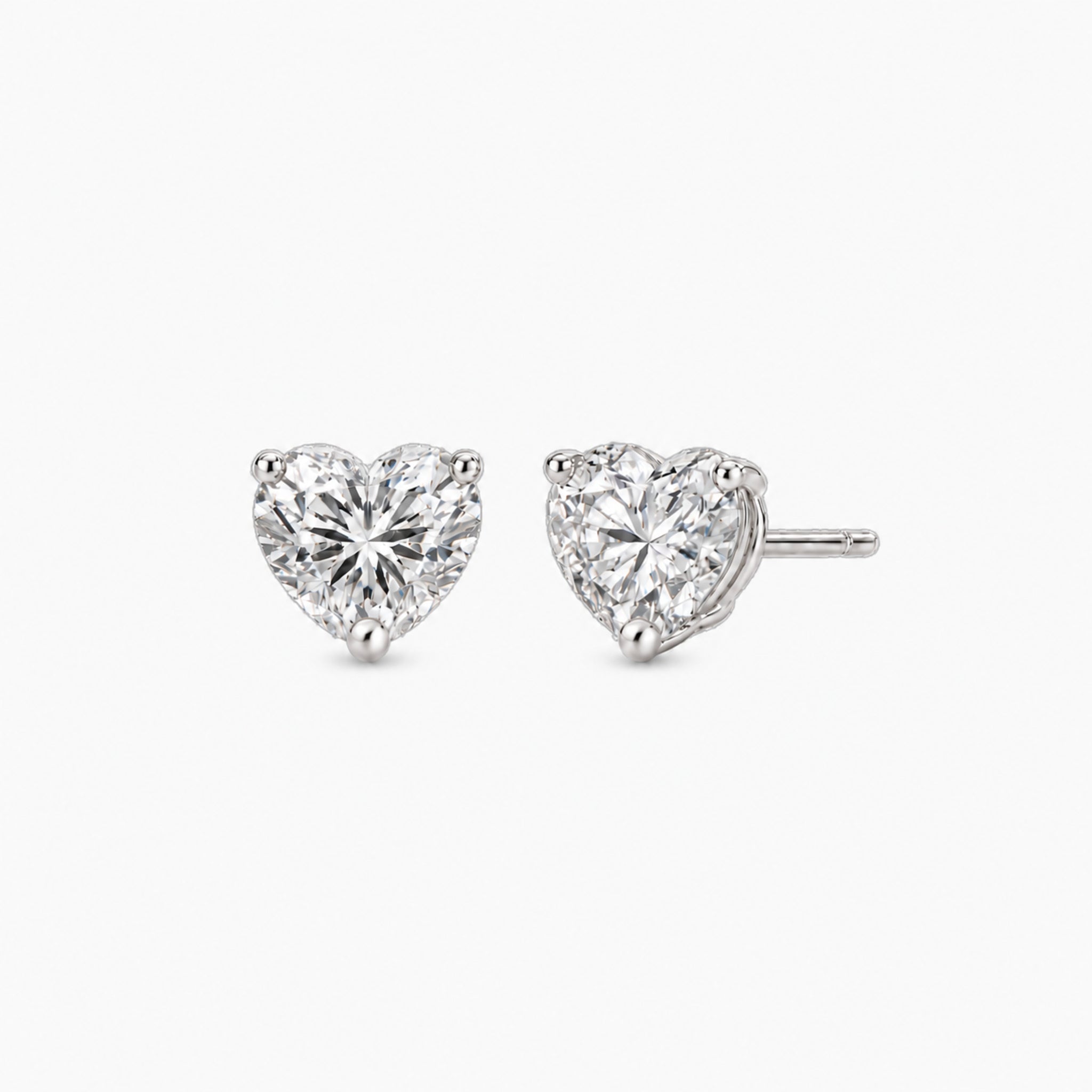 Heart-cut lab-grown diamond stud earrings in 14k white gold, front and three-quarter views.