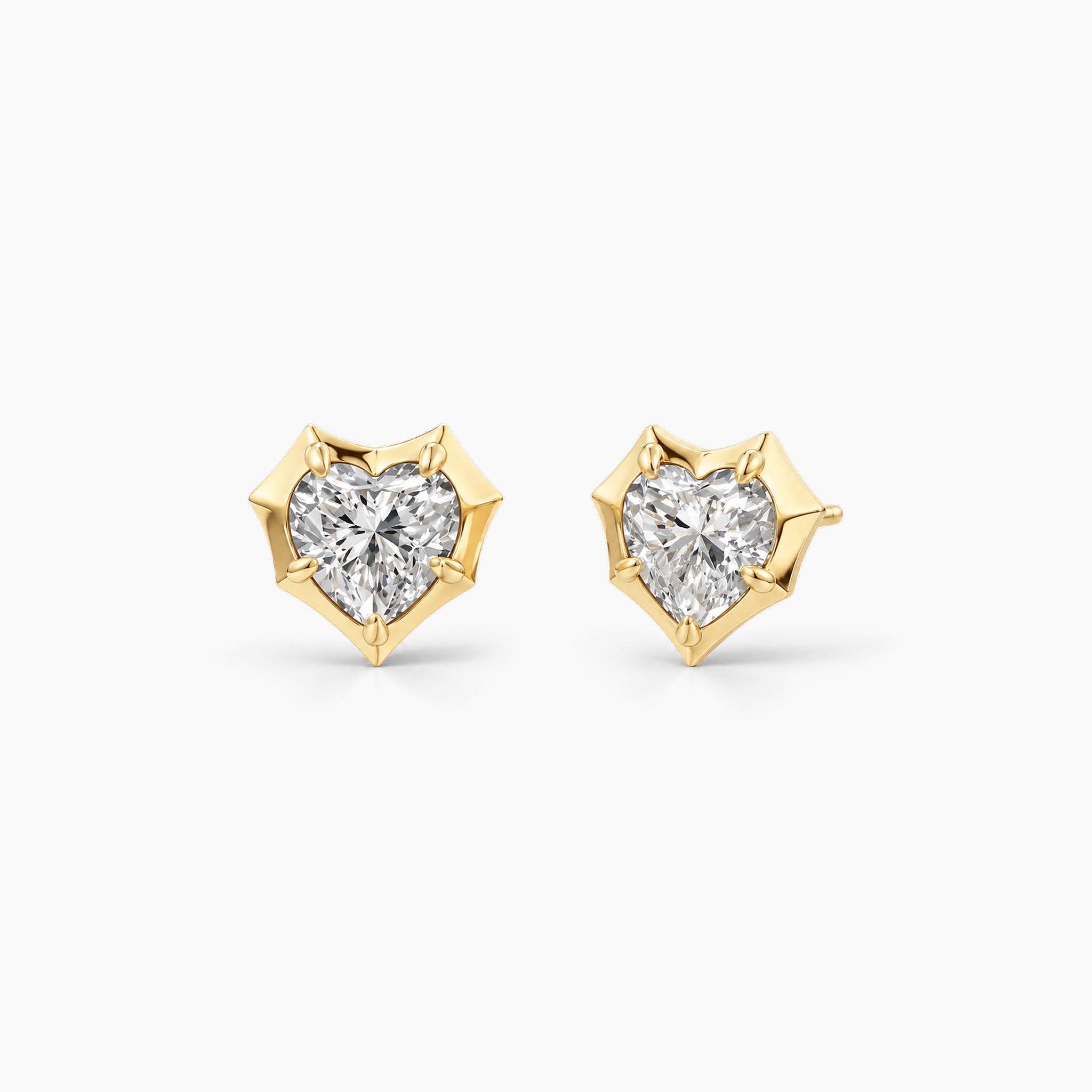 Heart-cut moissanite bezel-prong stud earrings in 18k yellow gold vermeil, front and angled views.