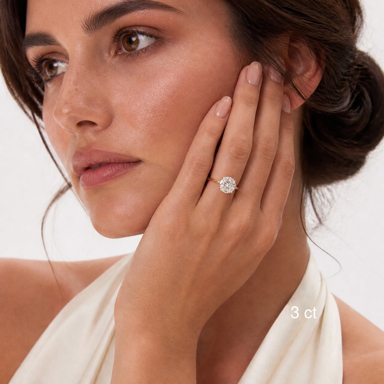 3 ct round-cut moissanite hidden halo ring in yellow gold worn on model.