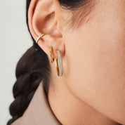 Large bold pavé moissanite hoop earrings worn on the ear.