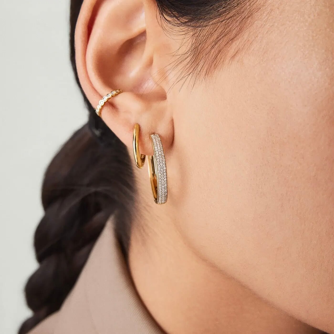 Large bold pavé moissanite hoop earrings worn on the ear.