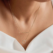 Layered pavé moissanite circle and bar necklace worn at the neckline.