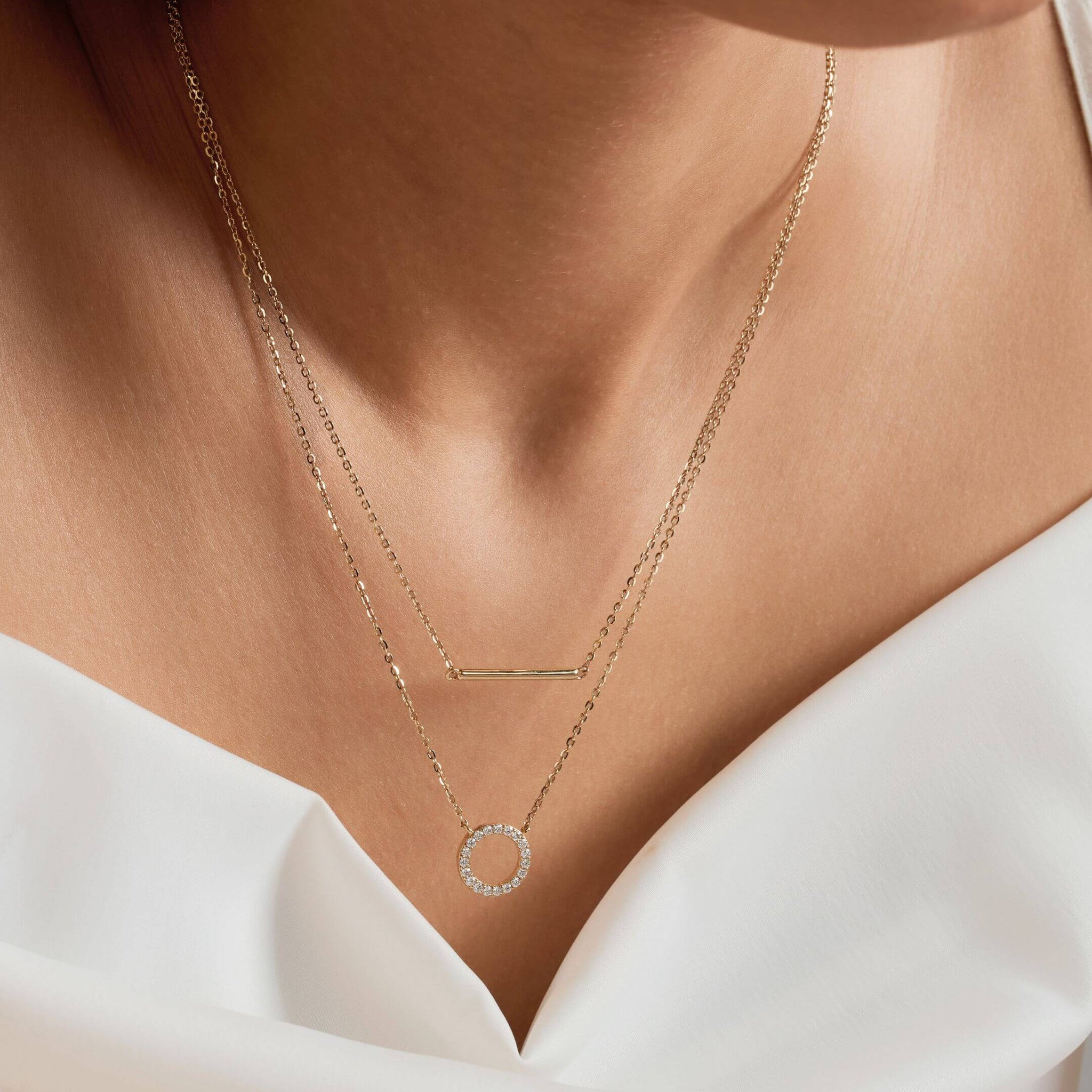 Layered pavé moissanite circle and bar necklace worn at the neckline.