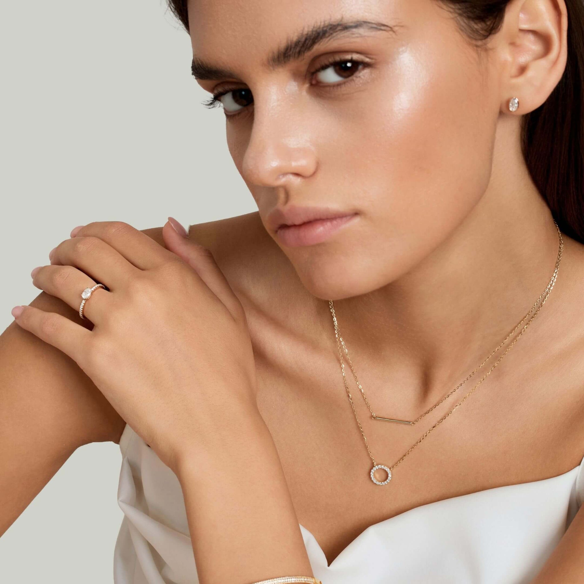 Layered pavé moissanite circle and bar necklace worn at the neckline.