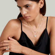 Layered pavé moissanite heart necklace worn at the neckline.