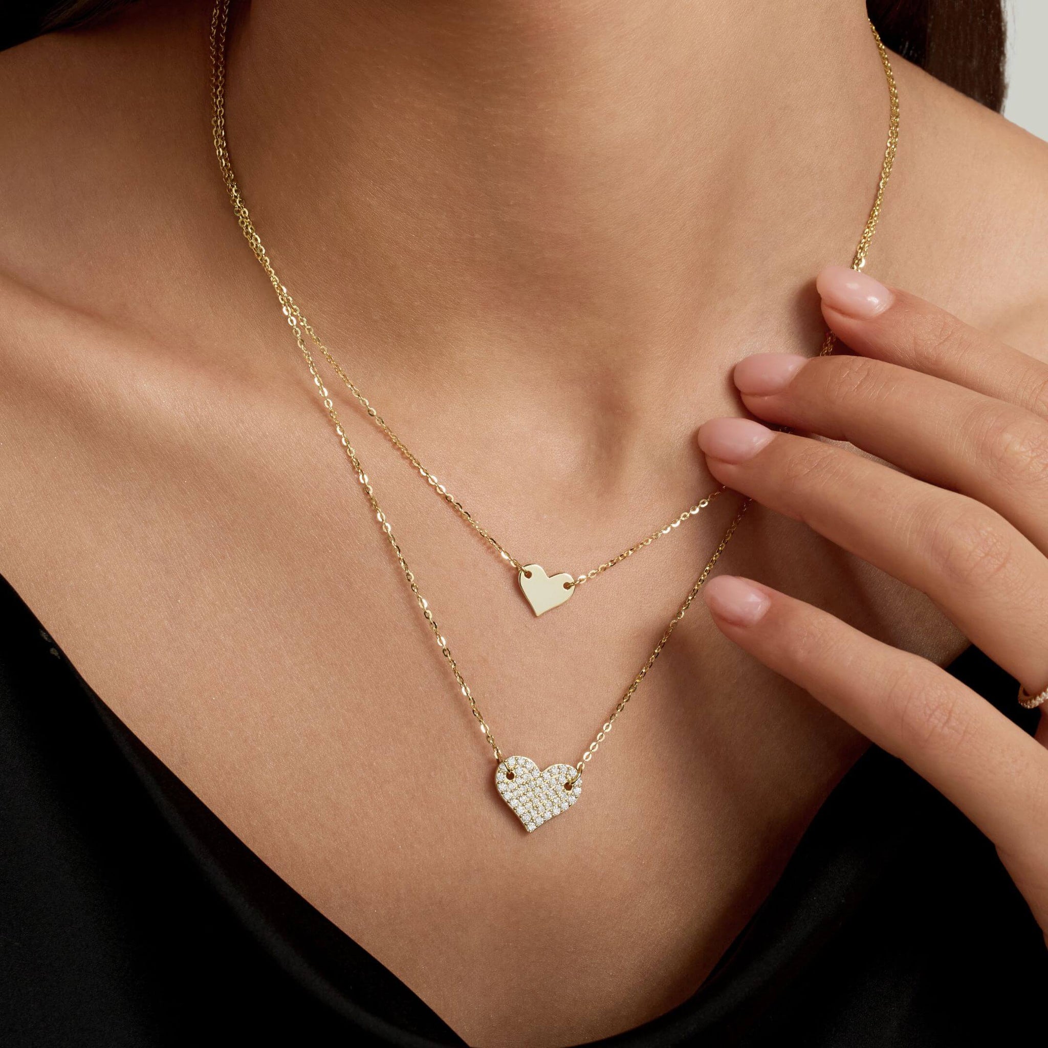 Layered pavé moissanite heart necklace worn at the neckline.