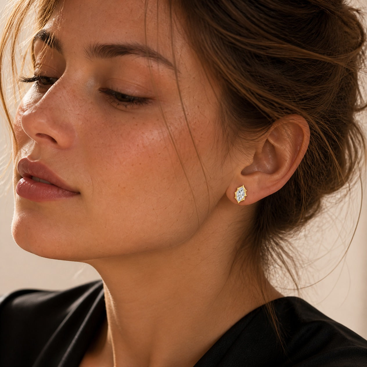 Marquise-cut moissanite bezel-prong stud earrings in yellow gold vermeil, worn by a model.