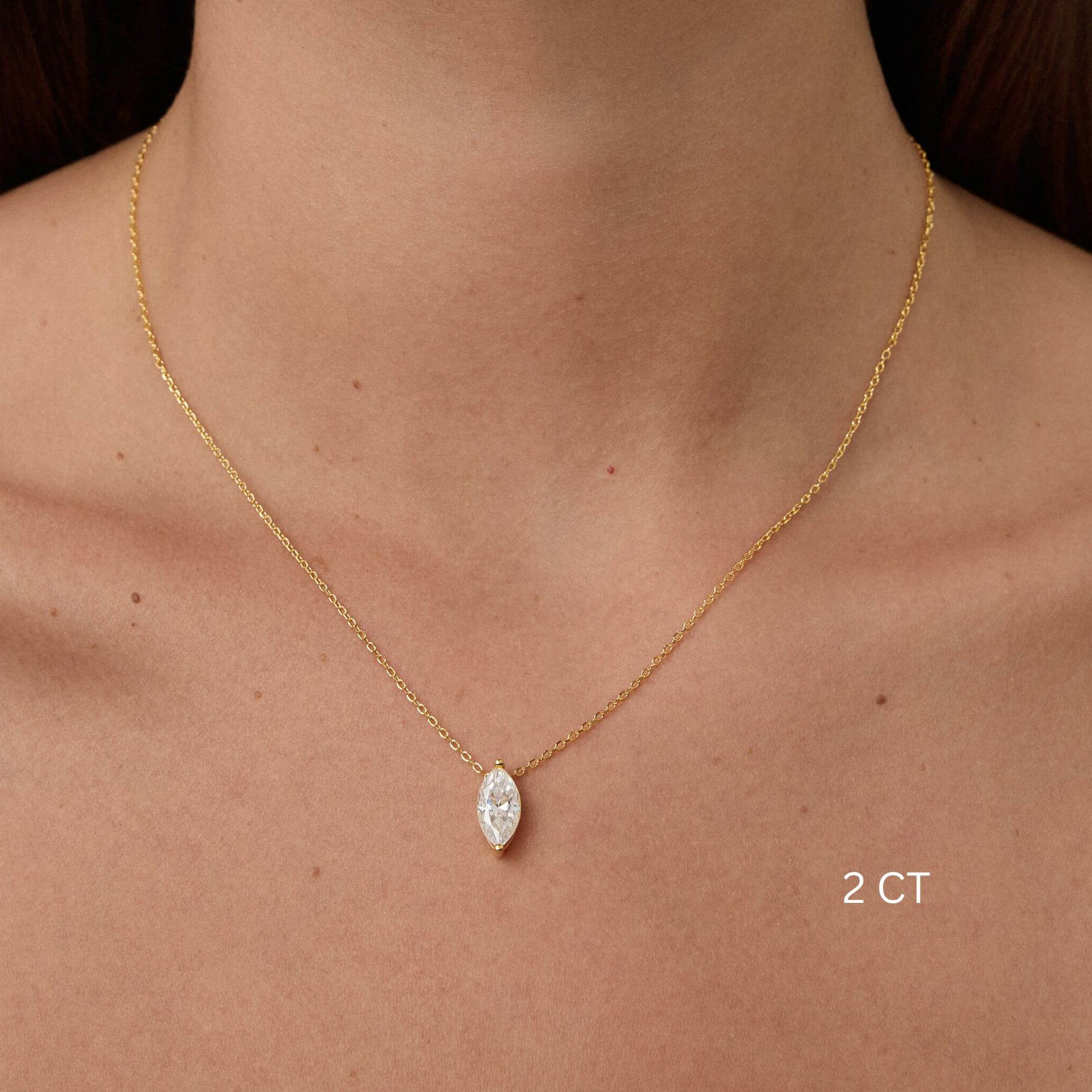 Marquise-cut moissanite pendant necklace worn at the neckline.