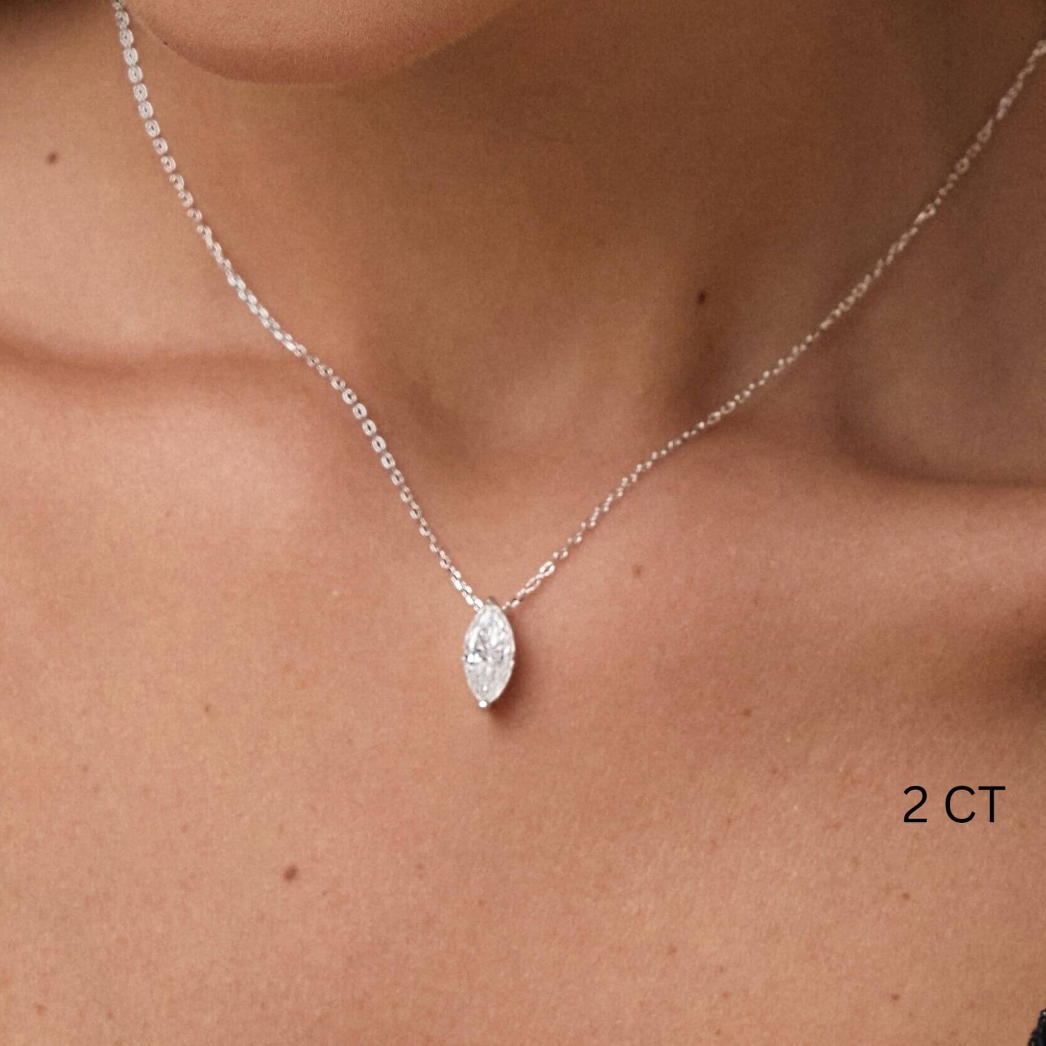 Marquise-cut moissanite pendant necklace worn at the neckline.