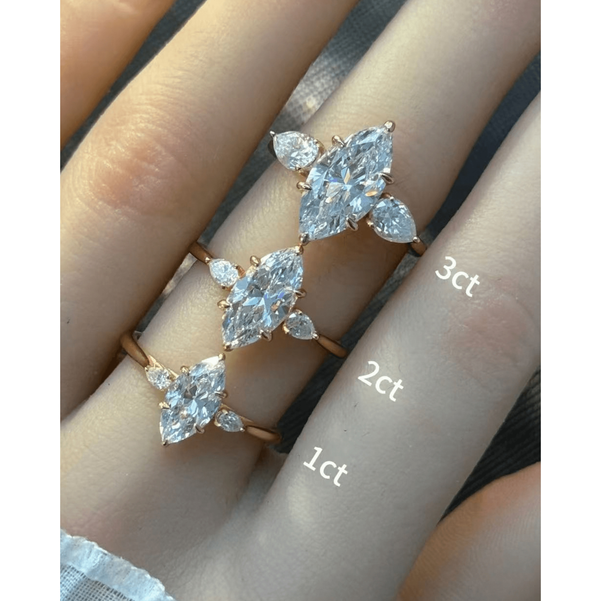 Marquise-cut moissanite three-stone ring rings arranged across fingers for a carat-size comparison.