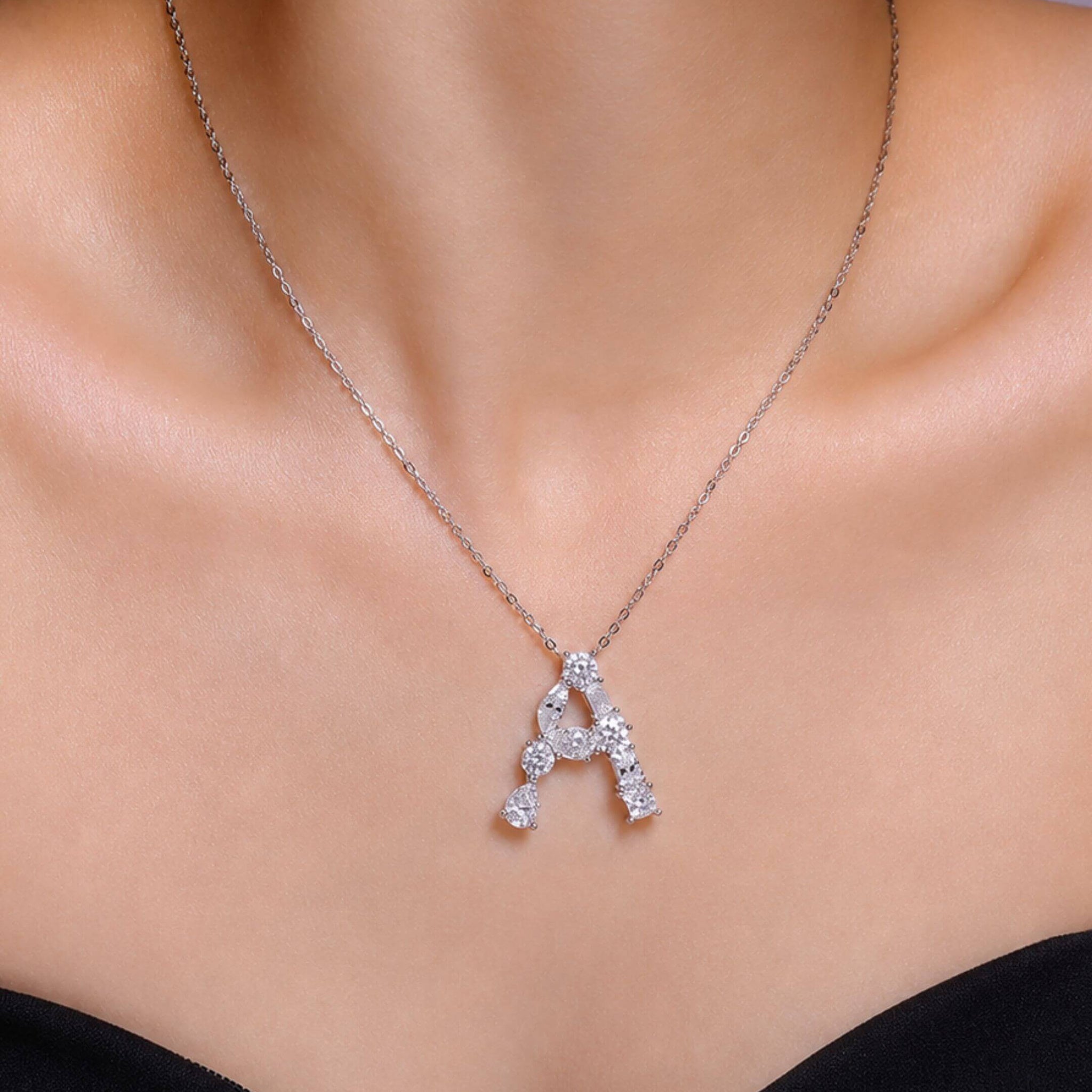 Mixed-shape moissanite initial necklace letter A pendant worn at the neckline.
