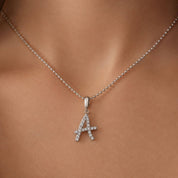 Moissanite abstract initial necklace letter A pendant worn at the neckline.