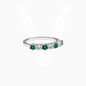 Moissanite and lab-grown emerald half eternity ring in white gold vermeil, angled view.