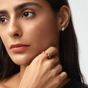 Moissanite and lab-grown ruby eternity ring worn on a finger.