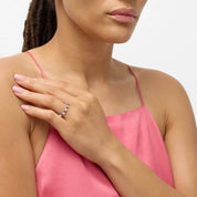 Moissanite and lab-grown ruby eternity ring worn on a finger.