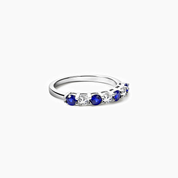 Moissanite and lab-grown sapphire half eternity ring in white gold vermeil, angled view.