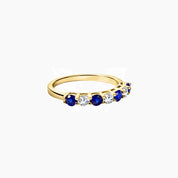 Moissanite and lab-grown sapphire half eternity ring in yellow gold vermeil, angled view.