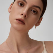 Moissanite bar drop earrings worn on the ear.