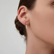 Moissanite bar drop earrings worn on the ear.
