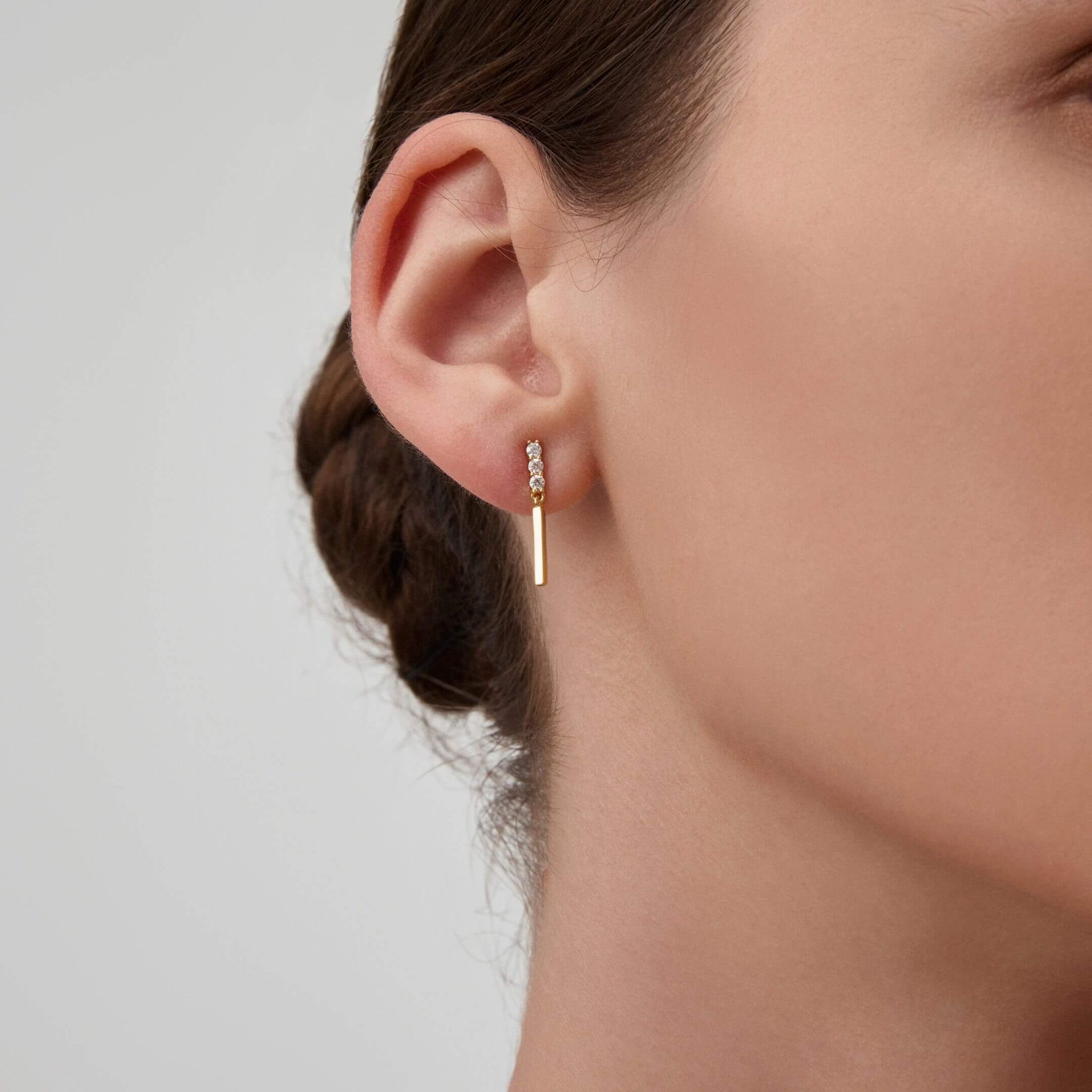 Moissanite bar drop earrings worn on the ear.
