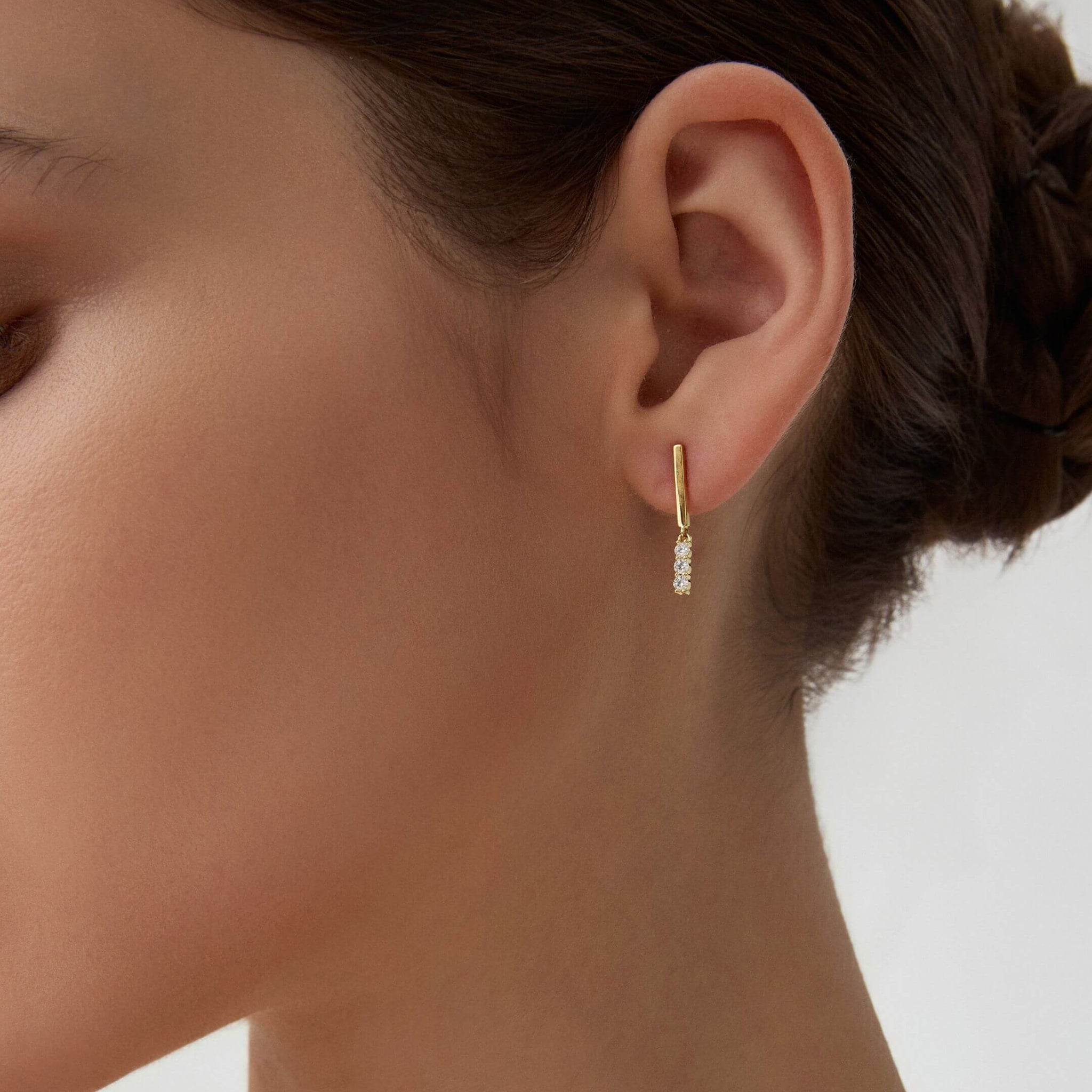 Moissanite bar drop earrings worn on the ear.