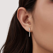 Moissanite bar drop earrings worn on the ear.