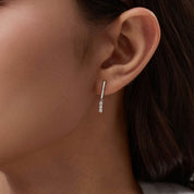 Moissanite bar drop earrings worn on the ear.