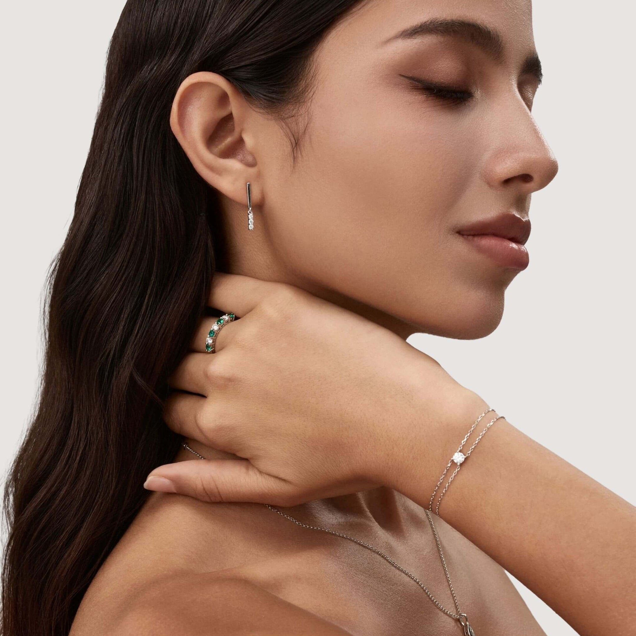 Moissanite bar drop earrings worn on the ear.