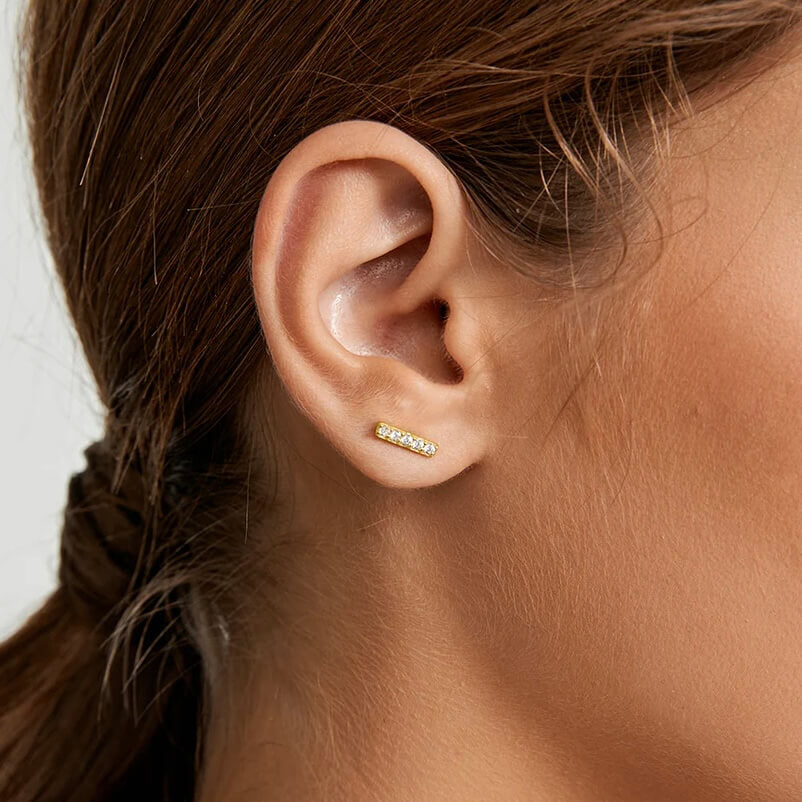 Moissanite bar stud earrings worn on the ear.