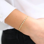 Moissanite bezel half tennis bracelet worn on the wrist.