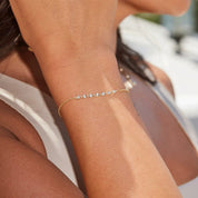 Moissanite bezel half tennis bracelet worn on the wrist.