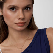 Moissanite bezel pendant necklace worn at the neckline.