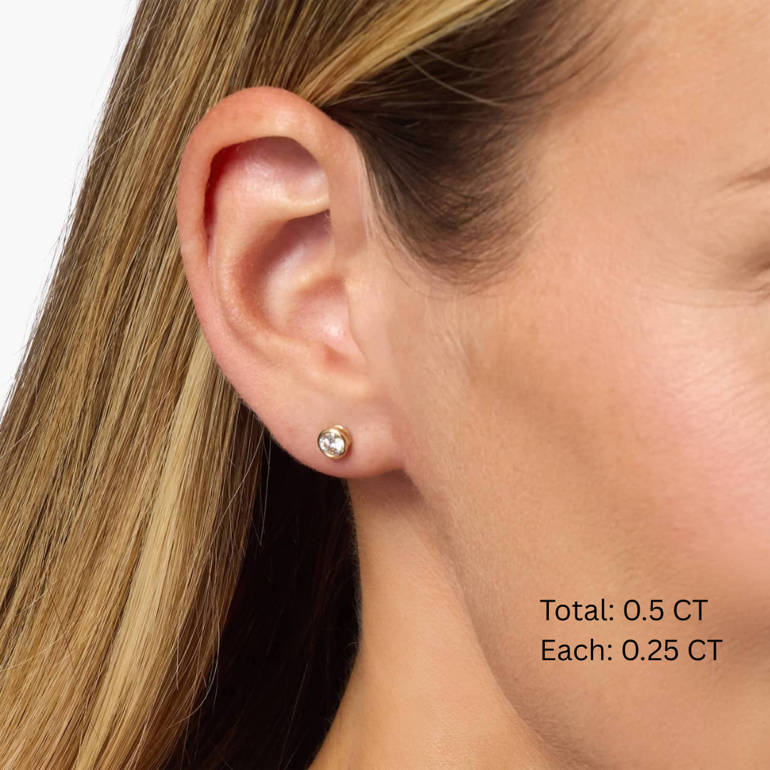 Moissanite bezel stud earrings worn on the ear, 0.5 ct per pair with 0.25 ct per stone.