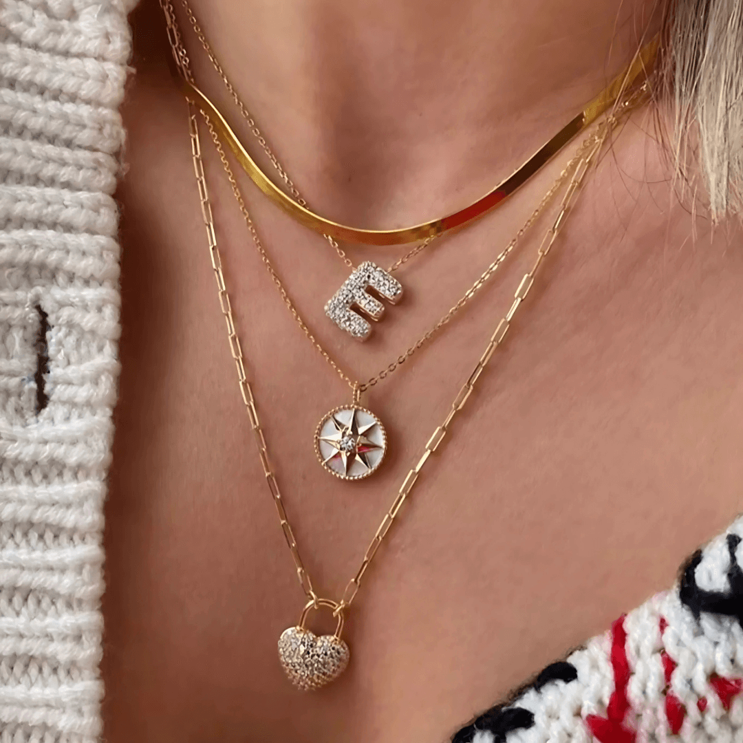 Moissanite bubble initial necklace initial pendant layered with other necklaces.