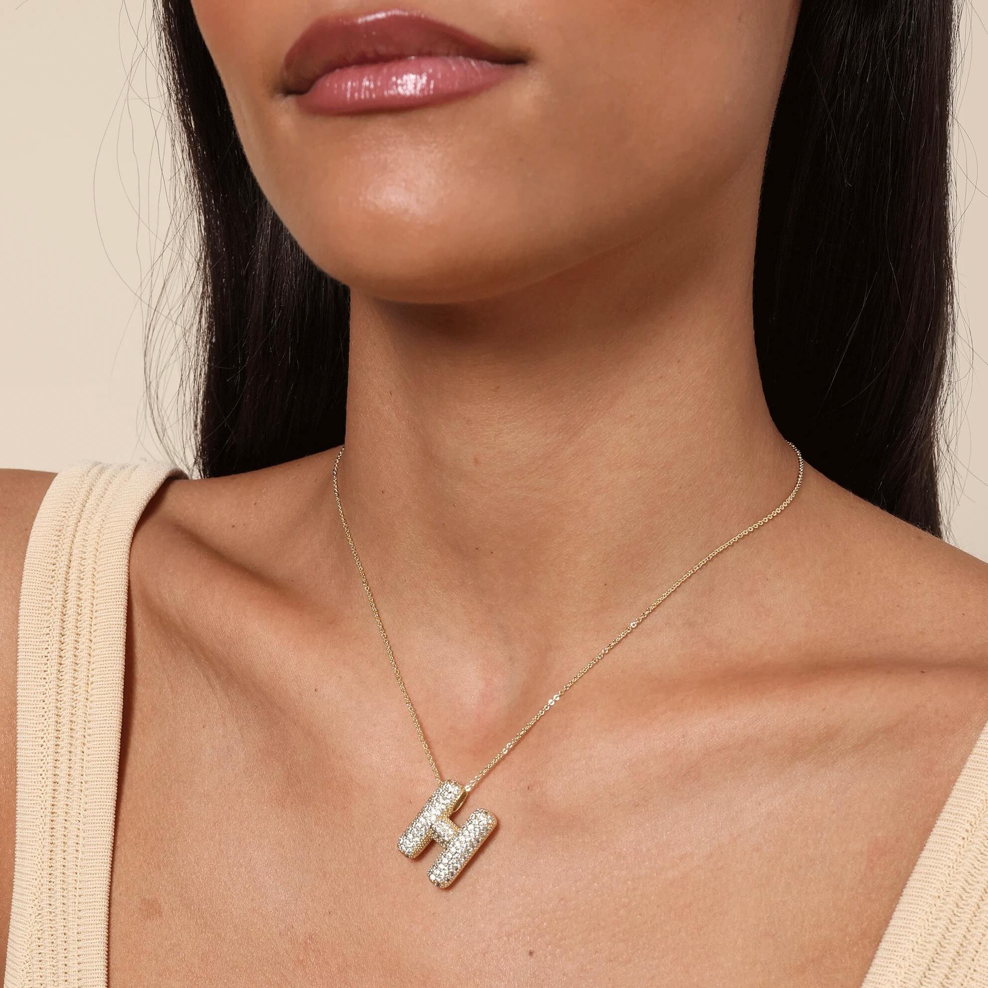 Moissanite bubble initial necklace letter H pendant worn at the neckline.