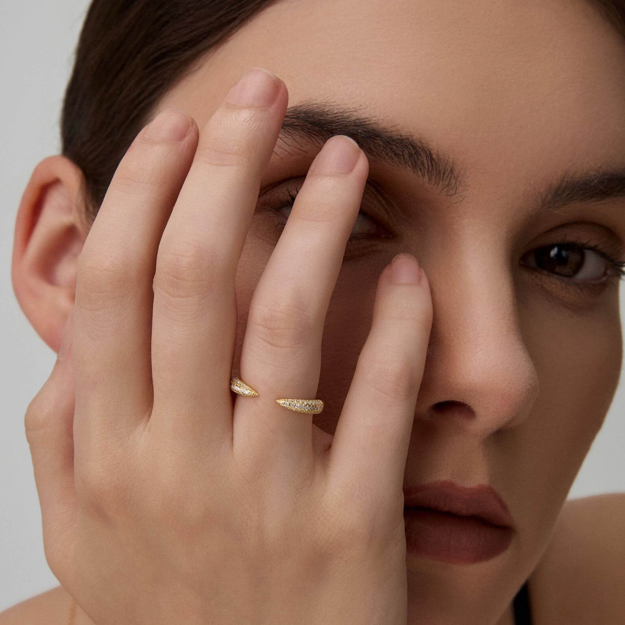 Moissanite claw ring worn on a finger.