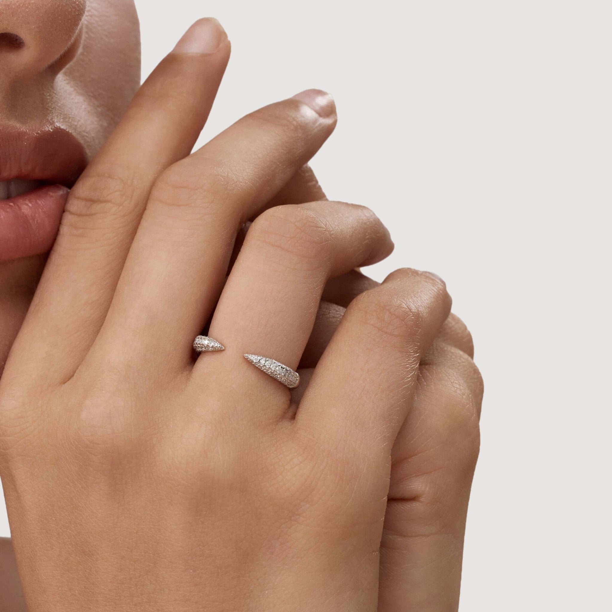 Moissanite claw ring worn on a finger.