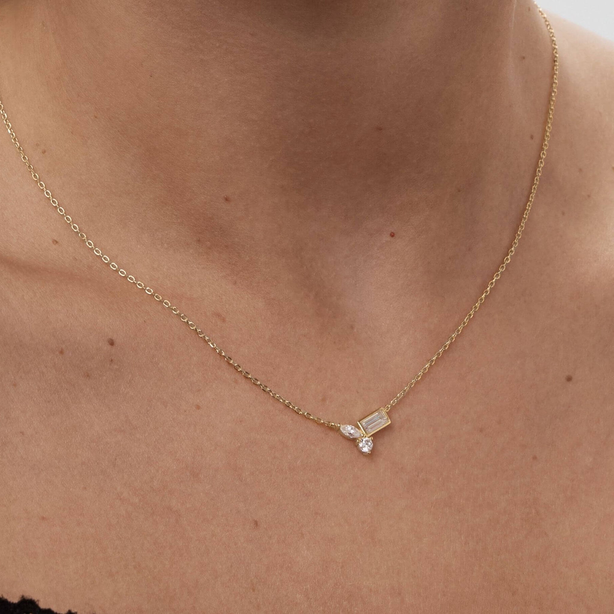 Moissanite cluster necklace worn at the neckline.