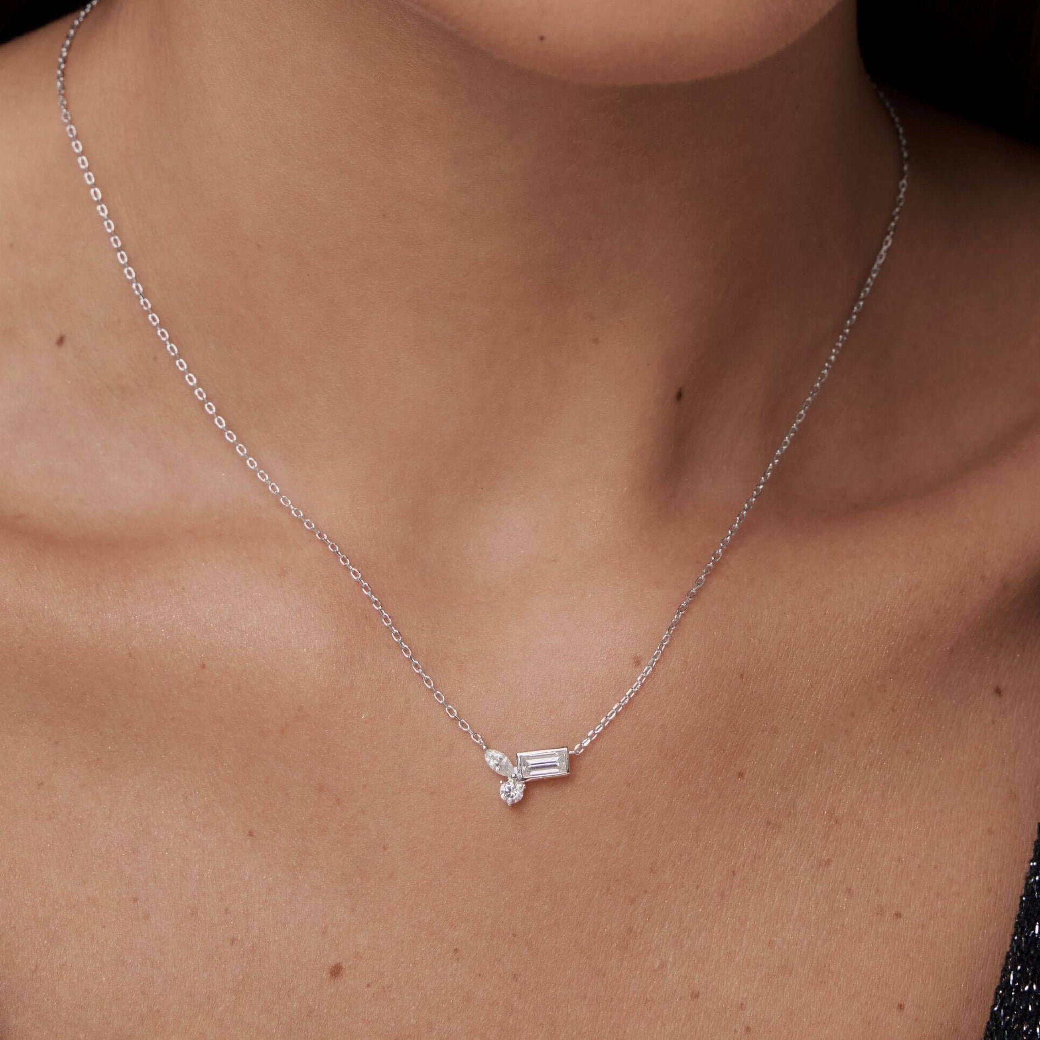 Moissanite cluster necklace worn at the neckline.