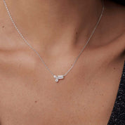 Moissanite cluster necklace worn at the neckline.
