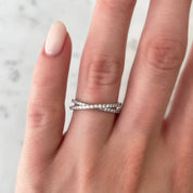 Moissanite crisscross ring worn on a finger.