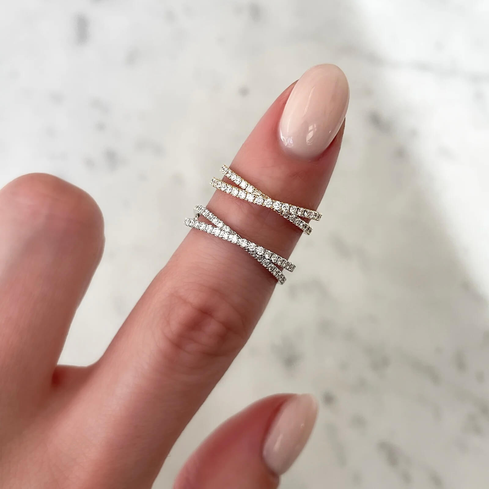 Moissanite crisscross ring worn on a finger.