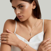 Moissanite cross necklace worn at the neckline.