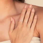 Moissanite cross ring worn on a finger.